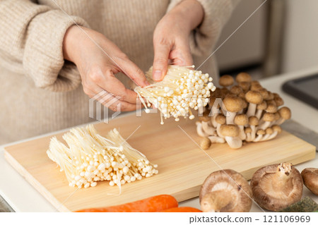 Woman's hands cutting mushrooms 121106969