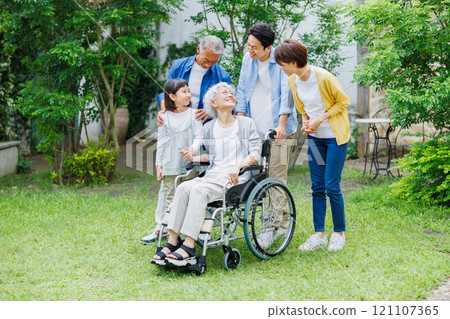 A friendly three-generation family with a grandmother in a wheelchair A friendly three-generation family with a grandmother in a wheelchair 121107365