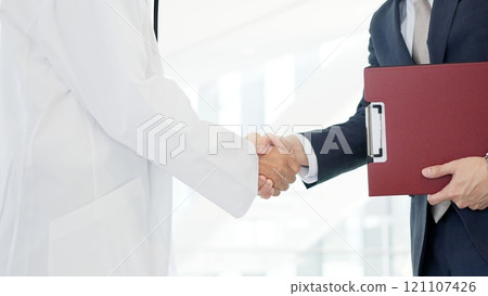 A doctor and a salesman shaking hands 121107426