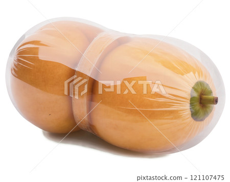 Sapodilla (Manilkara zapota) A smooth, round sapodilla wrapped in clear plastic. The fruit's brown, slightly rough skin is visible through 121107475