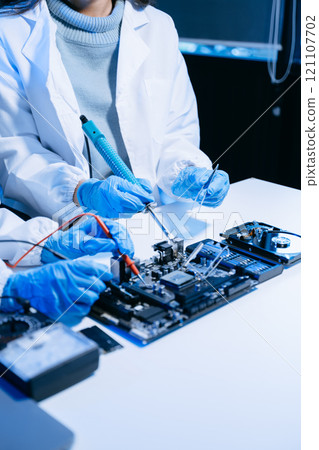 The technician is putting the CPU on the socket of the computer motherboard. electronic engineering electronic repair, electronics measuring 121107702