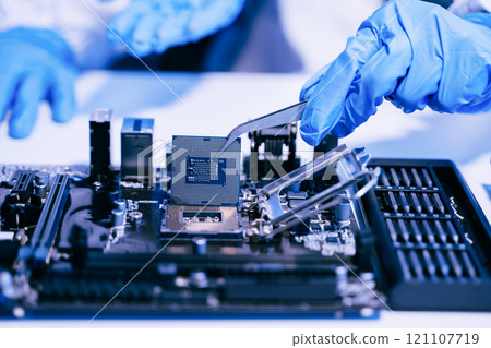 The technician is putting the CPU on the socket of the computer motherboard. electronic engineering electronic repair, electronics measuring 121107719
