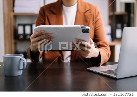 business documents on office table with smart phone and digital tablet and graph financial and woman working 121107721