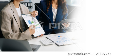 Business documents on office table with smart phone and laptop and two colleagues discussing data in the background Business documents on office table with smart phone and laptop and two colleagues discussing data in the background 121107732