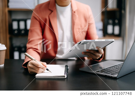 businesswoman hand working with new modern computer and writing on the notepad strategy diagram as concept businesswoman hand working with new modern computer and writing on the notepad strategy diagram as concept 121107748