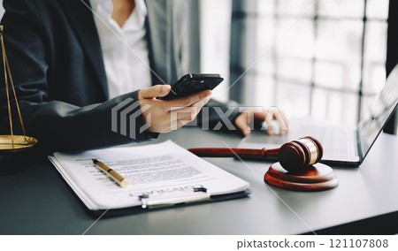justice and law concept. Male judge in a courtroom the gavel, working with smart phone and laptop and digital tablet computer on desk justice and law concept. Male judge in a courtroom the gavel, working with smart phone and laptop and digital tablet computer on desk 121107808
