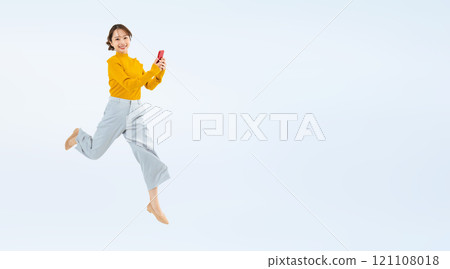 Full-body photo of a woman jumping with a smartphone 121108018