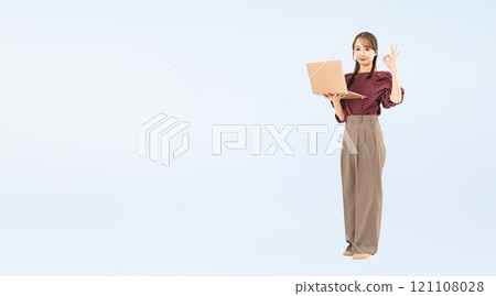 Full-body photo of a woman in casual wear holding a PC and showing an OK sign 121108028