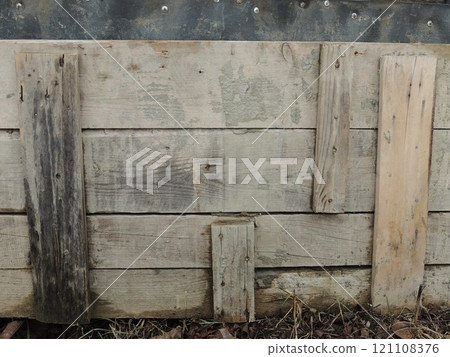fragment of a fence or railing made from pieces of old boards unevenly nailed to the base, abstract old wooden structure with weathered boards fragment of a fence or railing made from pieces of old boards unevenly nailed to the base, abstract old wooden structure with weathered boards 121108376
