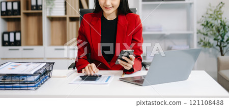 Asian Businesswoman Analyzing Finance on Tablet and Laptop at modern Office Desk tax Asian Businesswoman Analyzing Finance on Tablet and Laptop at modern Office Desk tax 121108488