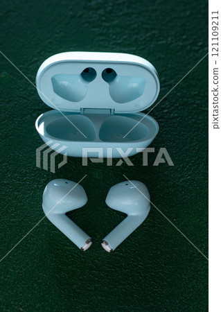 Wireless headphones on green background. Wireless, headphone in charging box. 121109211