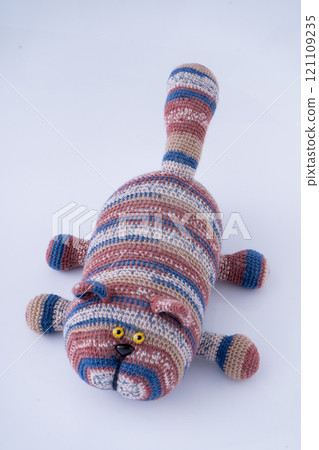 Crocheted toy cat. Melange thread. Hobby: knitting. Funny animal. Craft top view Crocheted toy cat. Melange thread. Hobby: knitting. Funny animal. Craft top view 121109235