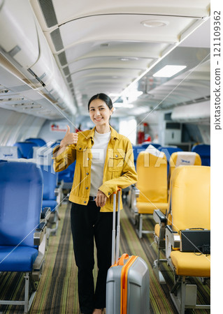 Asian businesswoman or entrepreneur in a formal suit on an airplane sitting in business class using a phone, computer laptop. Travel in style, Asian businesswoman or entrepreneur in a formal suit on an airplane sitting in business class using a phone, computer laptop. Travel in style, 121109362