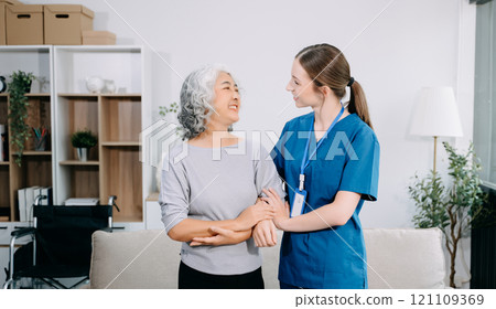 Young Caregiver doctor examine older patient use blood pressure gauge. woman therapist nurse at nursing home taking care of senior elderly woman sit on sofa. Young Caregiver doctor examine older patient use blood pressure gauge. woman therapist nurse at nursing home taking care of senior elderly woman sit on sofa. 121109369