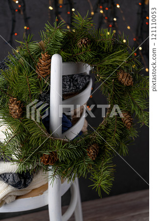 A Christmas wreath on a white chair 121110053