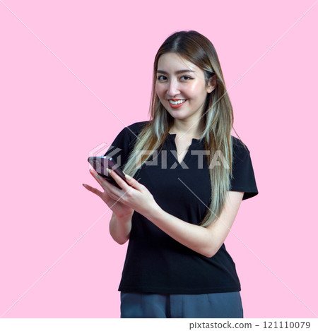 Young asian woman stand with a smile typing on smartphone. Portrait on pink background with studio light. Isolated. 121110079