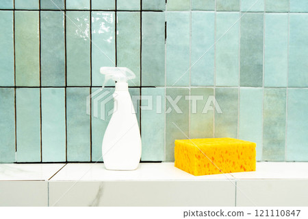 A tiled surface is prepped for repair with epoxy grout, adhesive, a spray bottle, and a sponge. A tiled surface is prepped for repair with epoxy grout, adhesive, a spray bottle, and a sponge. 121110847