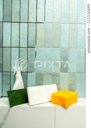 Epoxy adhesive is used for repairing a tiled surface in a bathroom with cleaning supplies nearby. Vertical photo. 121110849