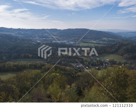 Panoramic view from viewpoint Stredni vrch near Dolni Prysk, Ceska Kamenice. Autumn landscape with colorful forest, hills and blue cloudy sky in Luzicke hory Lusatian Mountains, Czech Republic. Panoramic view from viewpoint Stredni vrch near Dolni Prysk, Ceska Kamenice. Autumn landscape with colorful forest, hills and blue cloudy sky in Luzicke hory Lusatian Mountains, Czech Republic. 121112310