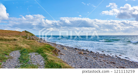 Coast of Kattegat - Helgenaes, Denmark. Ocean waves washing onto empty beach shore stones. Calm peaceful paradise of summer seascape and sky for relaxing fun holiday abroad or travel vacation 121113259