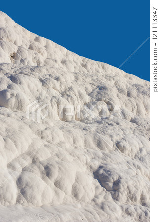 Scenic view of travertine pools and terraces in Pamukkale, Turkey. Traveling abroad, overseas for vacation and tourism. Cotton castle area with carbonate mineral after flowing thermal spring water Scenic view of travertine pools and terraces in Pamukkale, Turkey. Traveling abroad, overseas for vacation and tourism. Cotton castle area with carbonate mineral after flowing thermal spring water 121113347