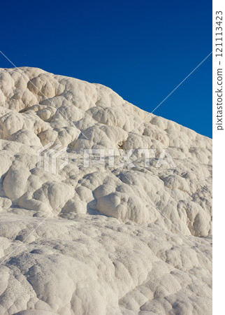 Closeup of travertine pools and terrace in Pamukkale, Turkey in a famous tourism holiday or vacation destination. Cotton castle area with carbonate mineral after flowing thermal spring water Closeup of travertine pools and terrace in Pamukkale, Turkey in a famous tourism holiday or vacation destination. Cotton castle area with carbonate mineral after flowing thermal spring water 121113423