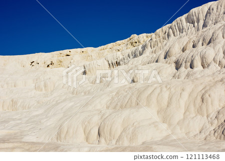 Scenic view of travertine pools and terraces in Pamukkale, Turkey. Traveling abroad, overseas for vacation and tourism. Cotton castle area with a carbonated mineral after flowing thermal spring water Scenic view of travertine pools and terraces in Pamukkale, Turkey. Traveling abroad, overseas for vacation and tourism. Cotton castle area with a carbonated mineral after flowing thermal spring water 121113468