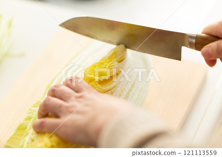 Woman's hands cutting Chinese cabbage 121113559
