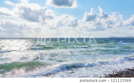 Coast of Kattegat - Helgenaes, Denmark. Ocean waves washing onto empty beach shore. Calm peaceful paradise of summer seascape and sky for relaxing fun holiday abroad or travel vacation overseas 121113569