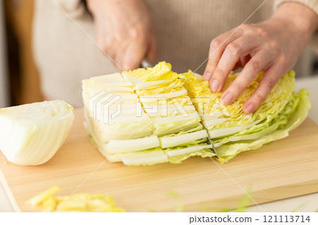 Woman's hands cutting Chinese cabbage 121113714
