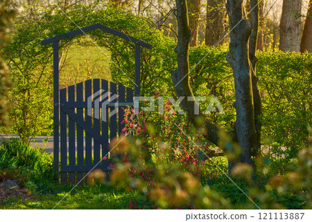 Small wooden gate in the countryside. Lush green garden upon entrance to private home in the woodlands. Sanctuary or safe haven in remote area in nature. Frontyard with trees, plants and green grass Small wooden gate in the countryside. Lush green garden upon entrance to private home in the woodlands. Sanctuary or safe haven in remote area in nature. Frontyard with trees, plants and green grass 121113887