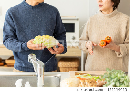 中年夫婦在廚房準備火鍋菜餚 中年夫婦在廚房準備火鍋菜餚 121114013