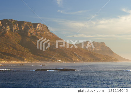 Landscape, sea, beach and mountain view of the Twelve Apostles in Cape Town, South Africa. Calm ocean with blue sky and copy space washing onto shores of famous hiking, travel or tourism destination 121114043