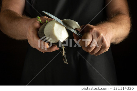 Hands skillfully peel a black radish, revealing its white interior in a cozy kitchen. A sharp knife glimmers under soft lighting, highlighting the artistry of food preparation Hands skillfully peel a black radish, revealing its white interior in a cozy kitchen. A sharp knife glimmers under soft lighting, highlighting the artistry of food preparation 121114320