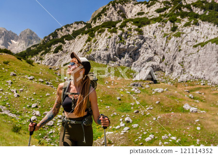 Woman Tourist with Backpack Hiking in Alps Woman Tourist with Backpack Hiking in Alps 121114352