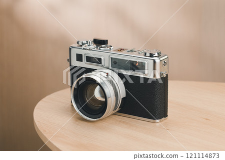 A classic rangefinder film camera sits elegantly. 121114873