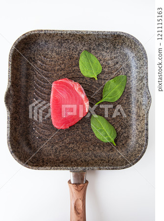 Fresh pink tuna lies on a grill pan, close-up. A delicious and healthy meal. 121115163