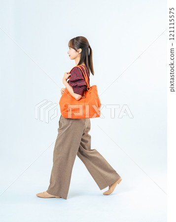 Full body photo of a walking woman in casual wear Full body photo of a walking woman in casual wear 121115575