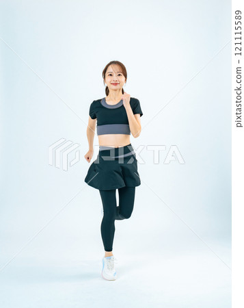 Full body photo of a woman running in sportswear 121115589