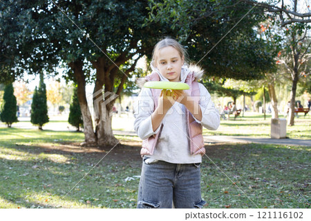 Young happy girl child playing flying disc in a sunny, green outdoor setting, exemplifying carefree Young happy girl child playing flying disc in a sunny, green outdoor setting, exemplifying carefree 121116102