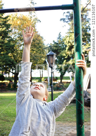 Active child girl on playground. Kids play outdoor.  121116107