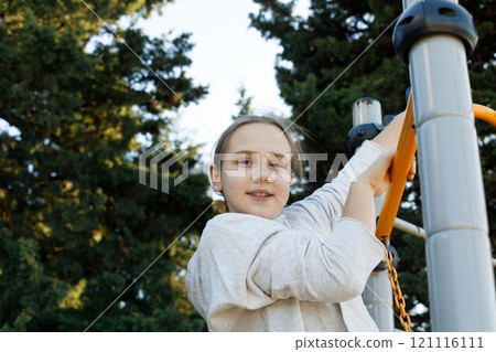 Cute child girl on playground. Kids play outdoor. Childhood, happiness and leisure activity concept Cute child girl on playground. Kids play outdoor. Childhood, happiness and leisure activity concept 121116111