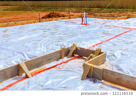 Preparing foundation for new building in site features covered area with protective plastic, surrounded by wooden frames Preparing foundation for new building in site features covered area with protective plastic, surrounded by wooden frames 121116510