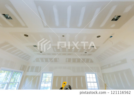 This is an interior room under renovation, with drywall partially finished, unpainted drywall on interior walls 121116562