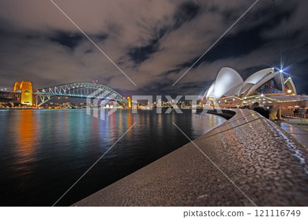 Sydney Harbour Bridge illuminated at night with reflections on calm water 121116749