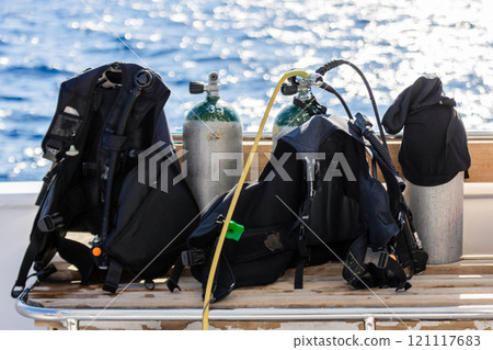 Concept of scuba diving with tank and equipment lying on a boat over blue sea and sunshine 121117683