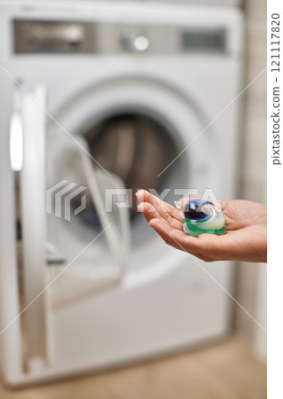 female hand putting capsule pod detergent for washing clothes into washing machine 121117820