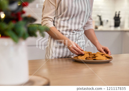 woman holding plate of delicious gingerbread cookies at home, Christmas time woman holding plate of delicious gingerbread cookies at home, Christmas time 121117835