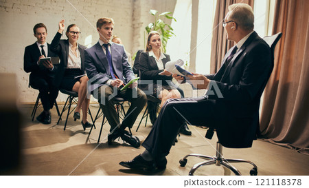 Senior leader, businessman engaging in meaningful discussion with team members during corporate meeting. Growing professional skills 121118378