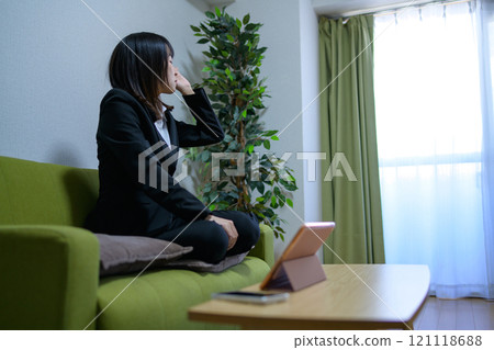 A woman living alone falls asleep on the sofa while looking at a tablet. Businesswoman waking up, working overtime. 121118688